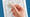 Female hand holding coin above magic script. 